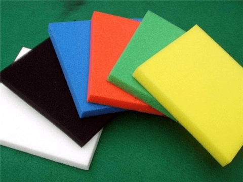 Assorted colorful foam sheets on a green background.