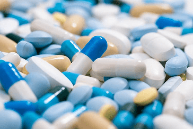 Close-up of assorted pharmaceutical capsules and tablets in various colors.