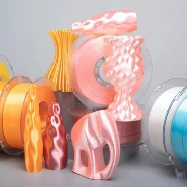 Colorful 3D printed objects and PLA filament spools, highlighting the use of PLA in sustainable 3D printing applications.