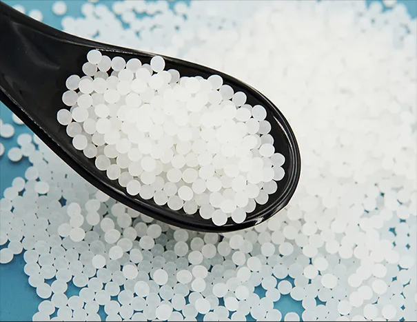 Spoonful of white Polylactic Acid (PLA) pellets, a biodegradable and eco-friendly plastic alternative.