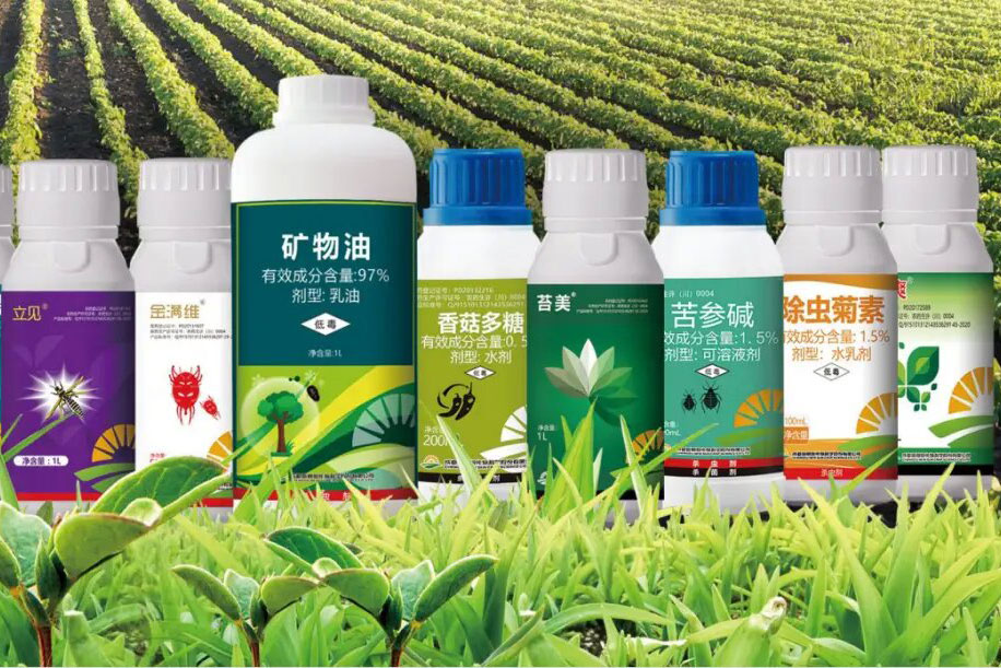 Assortment of pesticide bottles against a backdrop of lush green crops.