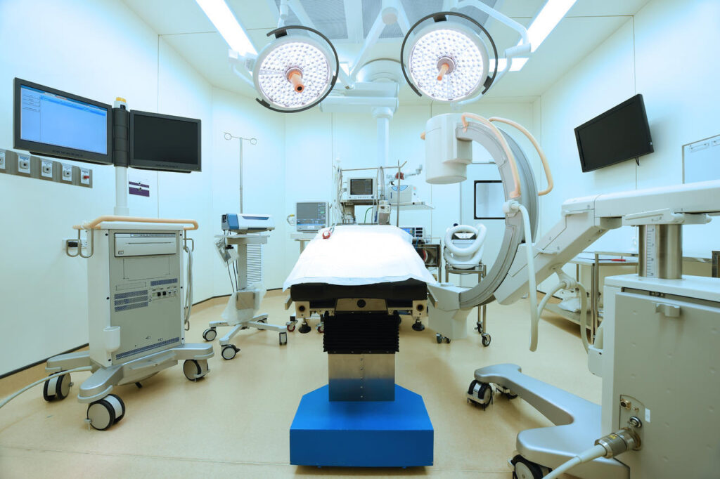 Modern operating room with advanced medical equipment and surgical lights.