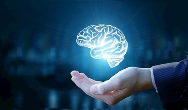 Digital image of a glowing brain floating above a hand, symbolizing brain health and cognitive function benefits from MCT oil supplementation.