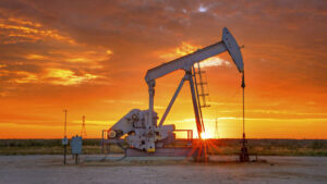 Oil pump jack operating at sunset, symbolizing the vital role of chemicals in enhancing oil and gas production.