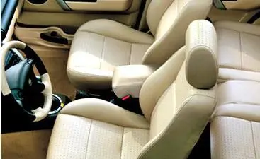 Car interior with beige polyurethane upholstery on seats and steering wheel.